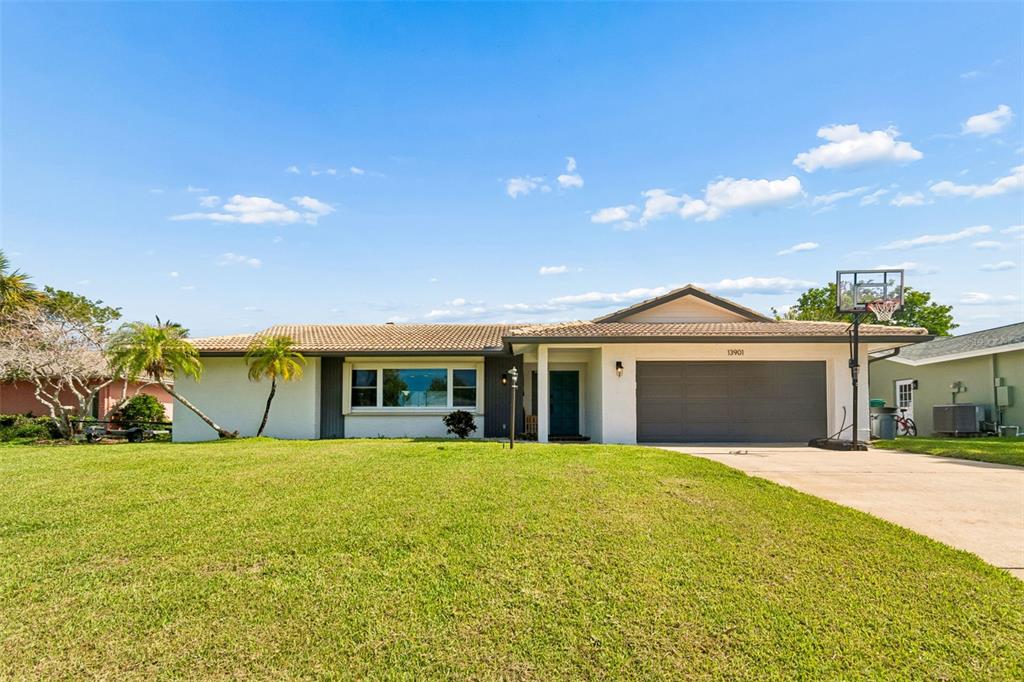 A single-story house with a white exterior, a two-car garage, and a large front lawn — 13901 88TH TERRACE, SEMINOLE, FL