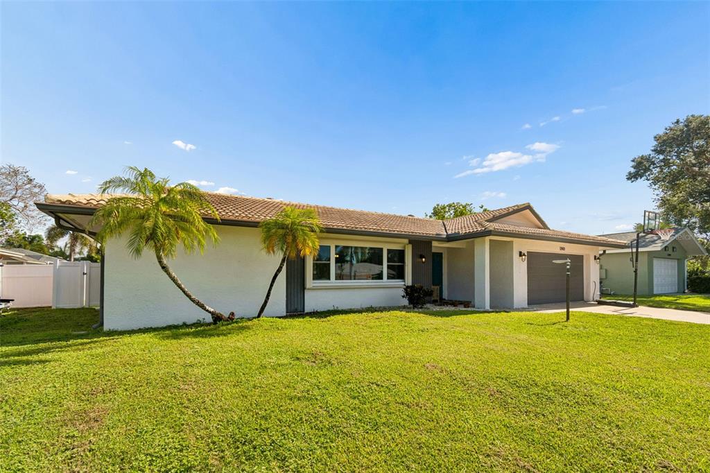 A single-story house with a white exterior, a tiled roof, and two palm trees — 13901 88TH TERRACE, SEMINOLE, FL