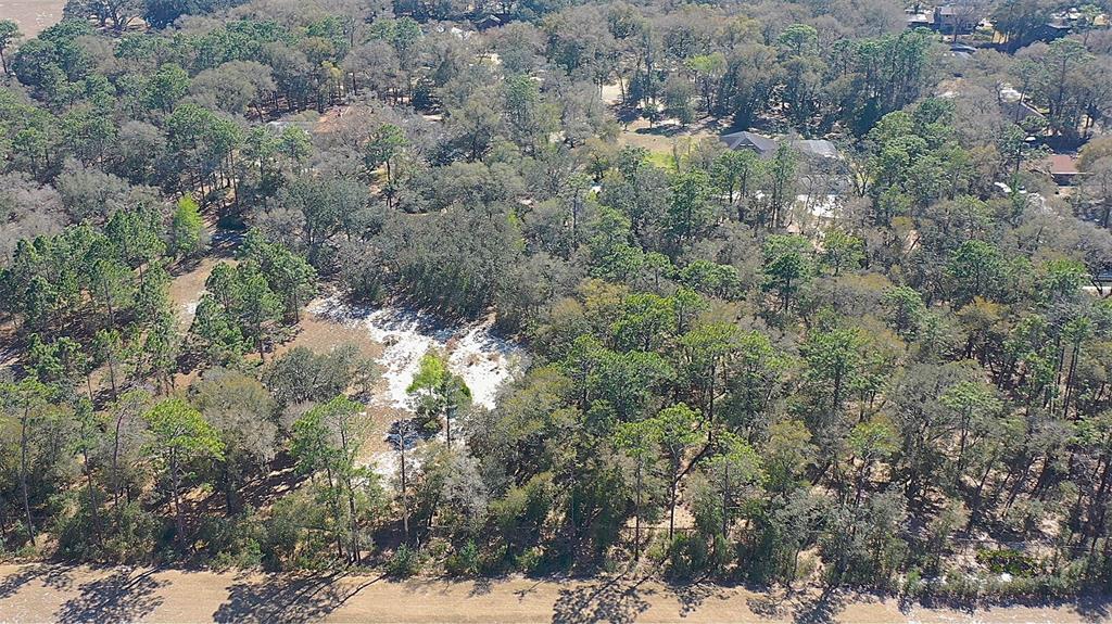 An aerial view shows a wooded lot with a sandy clearing and nearby residential homes — LINCOLN ROAD, DELAND, FL