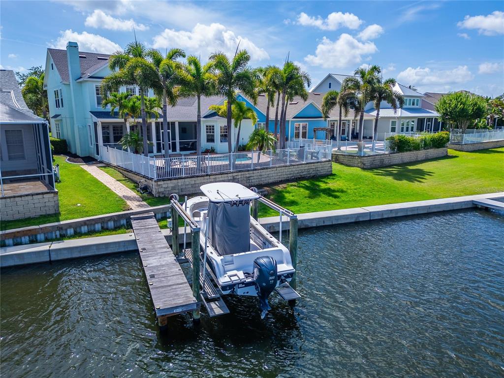 A boat is docked at a wooden pier in front of a waterfront house — 5722 SEA TROUT PLACE, APOLLO BEACH, FL