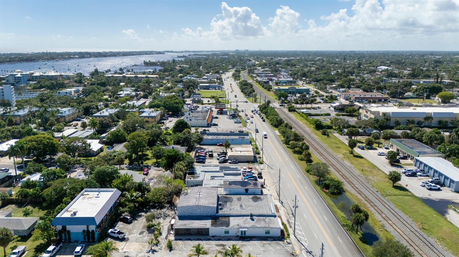 An aerial view shows a commercial building, a road, and railroad tracks near a waterway — 604 N Dixie Highway, Lantana FL 33462, LANTANA, FL