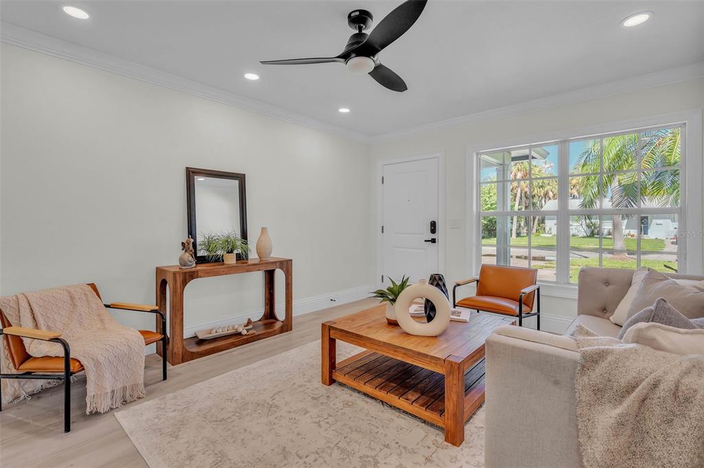 A bright living room features a wooden coffee table, two accent chairs, and a sofa — 965 BRUCE AVENUE, CLEARWATER BEACH, FL