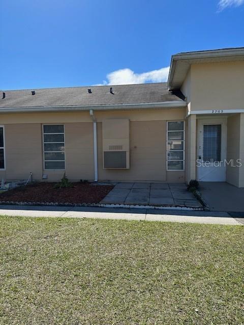 The exterior of a single-story tan building features a front door and two windows — 2709 CLUB CIRCLE, LAKE WALES, FL