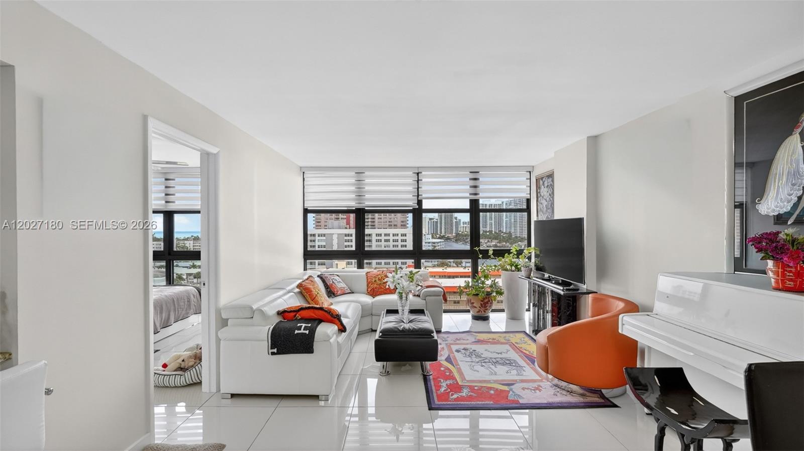 A bright living room features white tile floors, a sectional sofa, and floor-to-ceiling windows — 2017 S Ocean Dr # 1104, Hallandale Beach FL 33009, HALLANDALE BEACH, FL