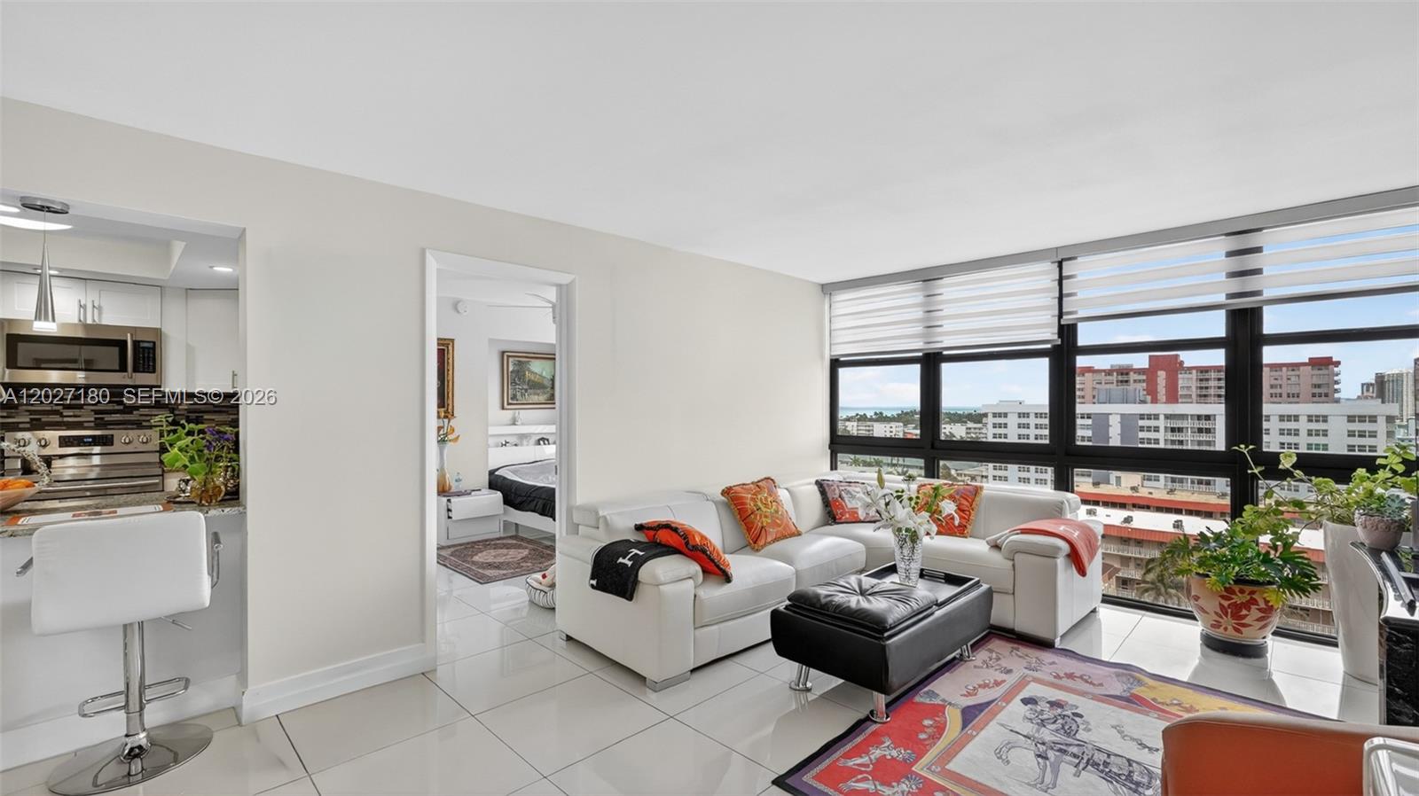 A living room with white tile floors, a white sectional sofa, and floor-to-ceiling windows — 2017 S Ocean Dr # 1104, Hallandale Beach FL 33009, HALLANDALE BEACH, FL