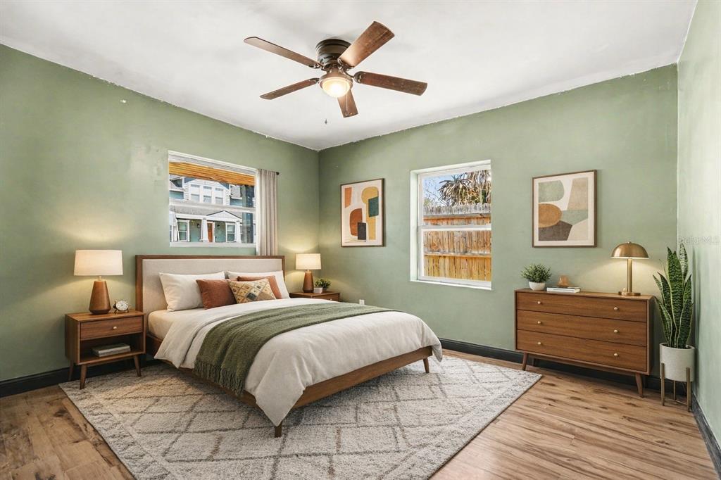A bedroom features sage green walls, a wooden bed frame, and a mid-century modern dresser — 1221 E EMMA STREET, TAMPA, FL