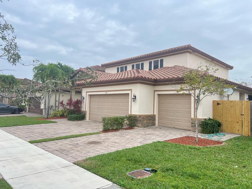 A two-story house with a three-car garage, tile roof, and paved driveway — 191 SE 35th Ave, Homestead FL 33033, HOMESTEAD, FL