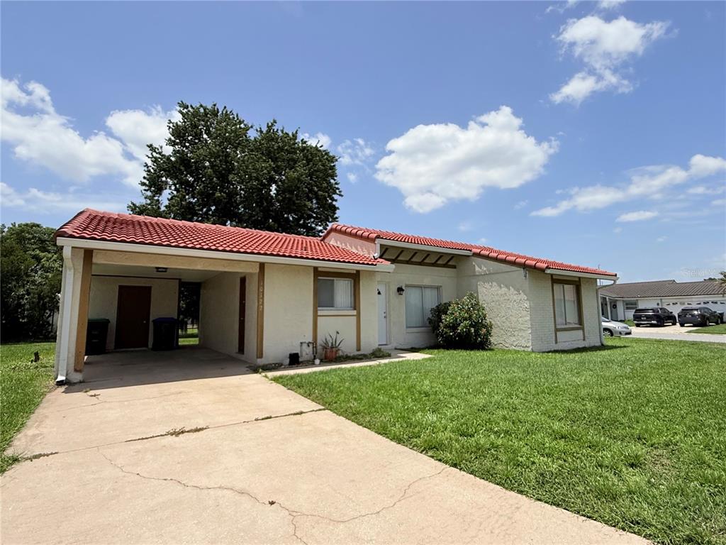 A single-story house with a red tile roof, stucco exterior, and an attached carport — 10122 MASON DIXON CIRCLE, ORLANDO, FL