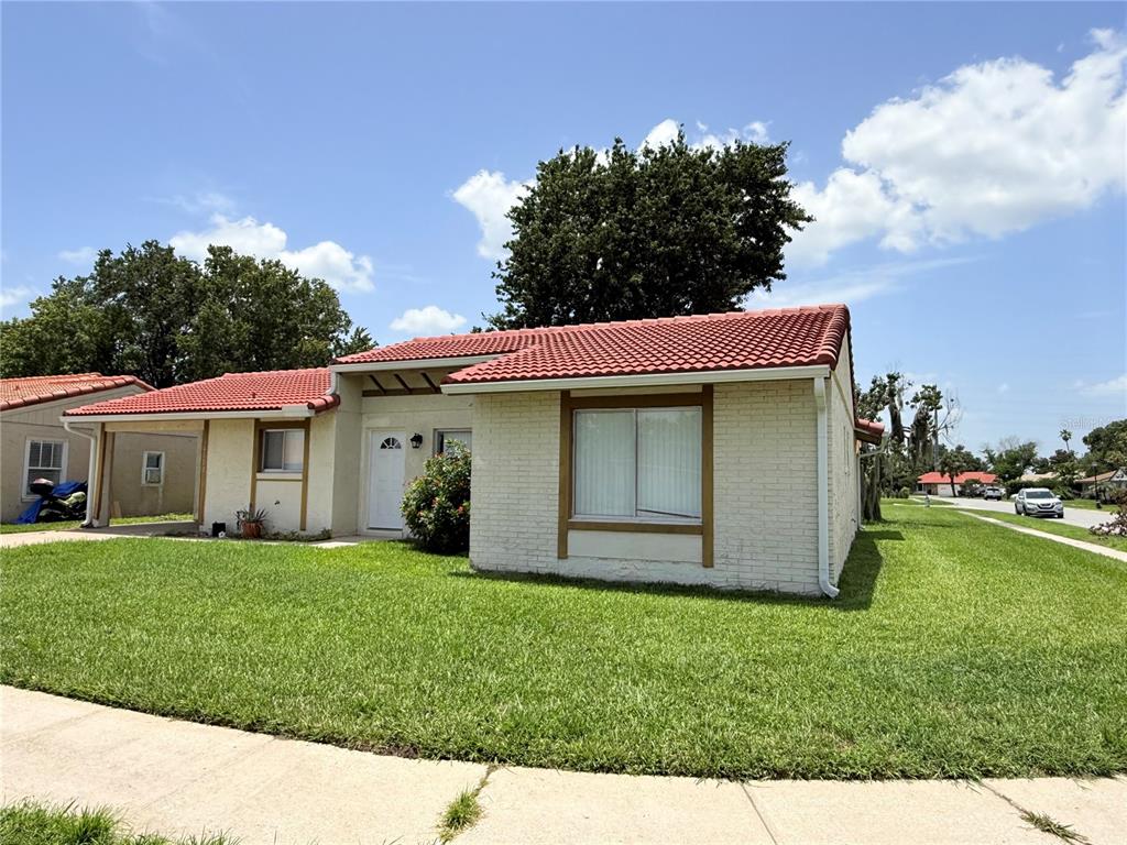 A single-story house with a red tile roof, white brick exterior, and a front lawn — 10122 MASON DIXON CIRCLE, ORLANDO, FL