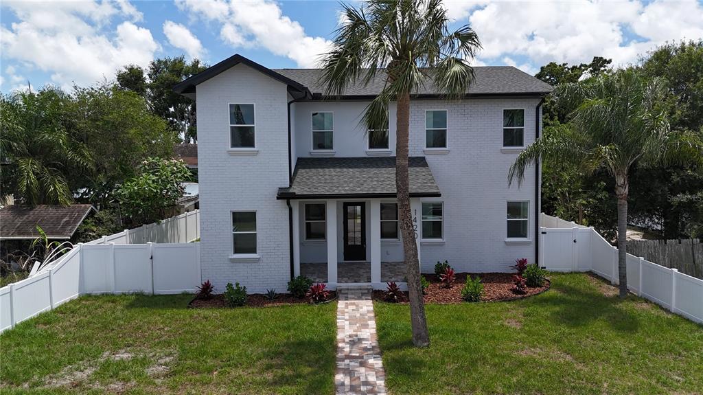 A two-story white brick house features a front porch, a palm tree, and a walkway — 1420 36TH AVENUE N, ST PETERSBURG, FL