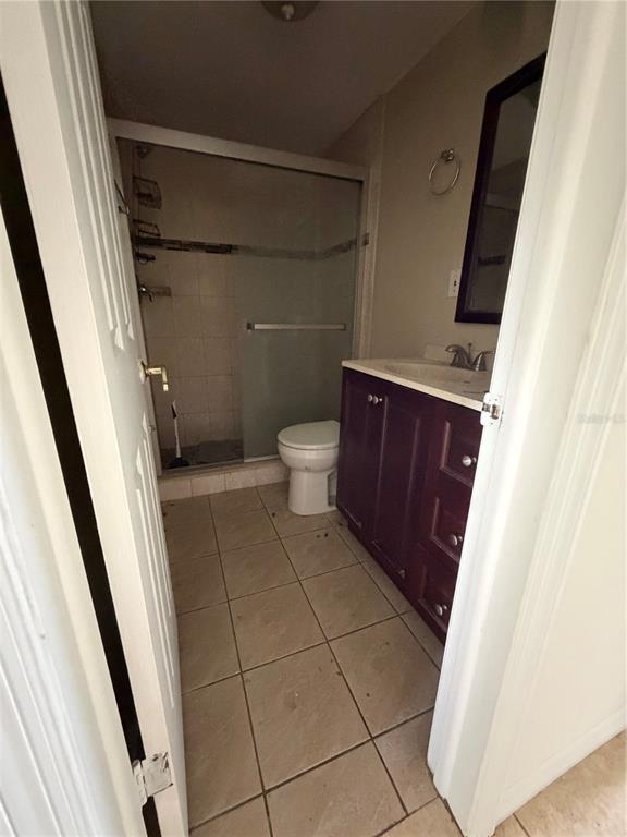 A bathroom features a dark wood vanity, a toilet, and a glass-enclosed shower stall — 4138 STAR ISLAND DRIVE, HOLIDAY, FL