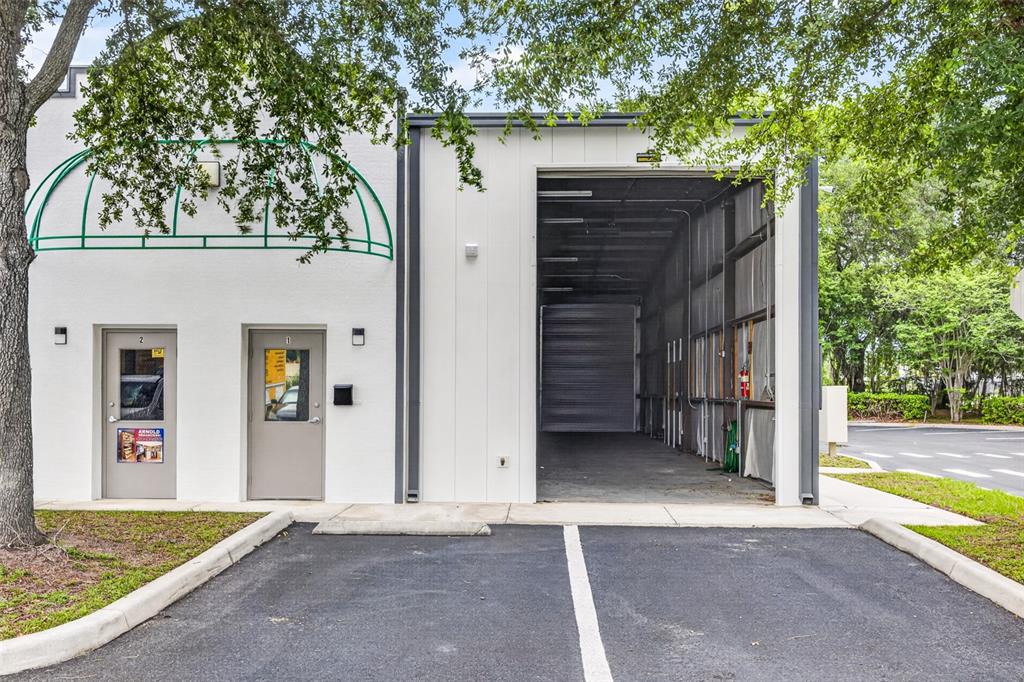 The exterior of a commercial building features two entry doors and an open bay garage — 7064 SAMPEY ROAD UNIT 1, GROVELAND, FL