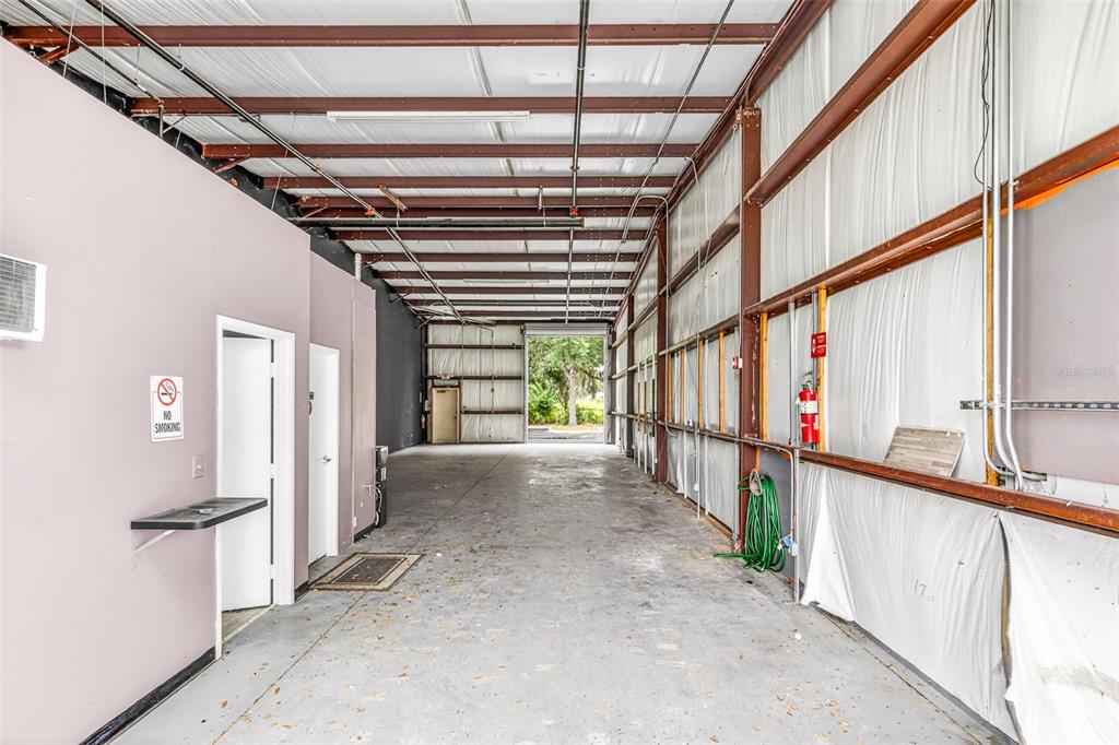 An interior view of a long, industrial warehouse space with concrete floors and metal walls — 7064 SAMPEY ROAD UNIT 1, GROVELAND, FL