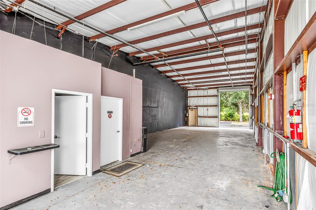 An industrial warehouse space features concrete floors, exposed steel beams, and two interior doors — 7064 SAMPEY ROAD UNIT 1, GROVELAND, FL