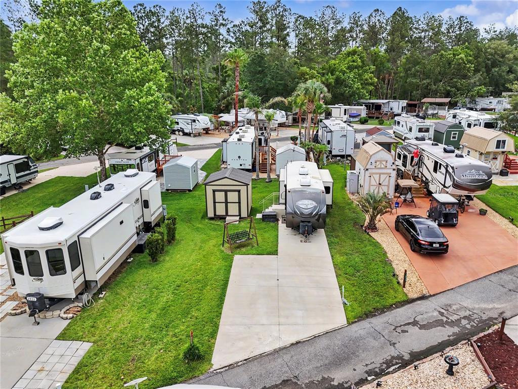 An aerial view of a residential RV park featuring multiple trailers, sheds, and paved driveways — 2923 NE 104TH AVENUE, SILVER SPRINGS, FL