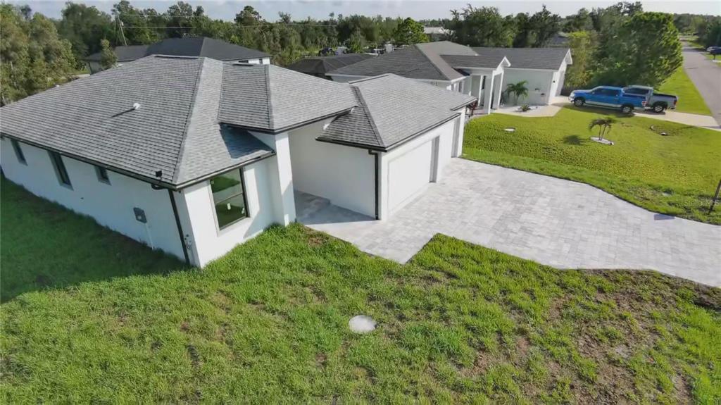 An aerial view of a modern white house with a gray roof and paved driveway — 9309 ZORN STREET, PORT CHARLOTTE, FL