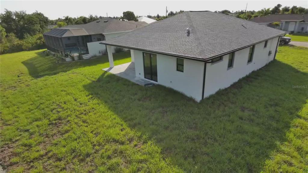 An aerial view of the back of a white house with a covered patio — 9309 ZORN STREET, PORT CHARLOTTE, FL
