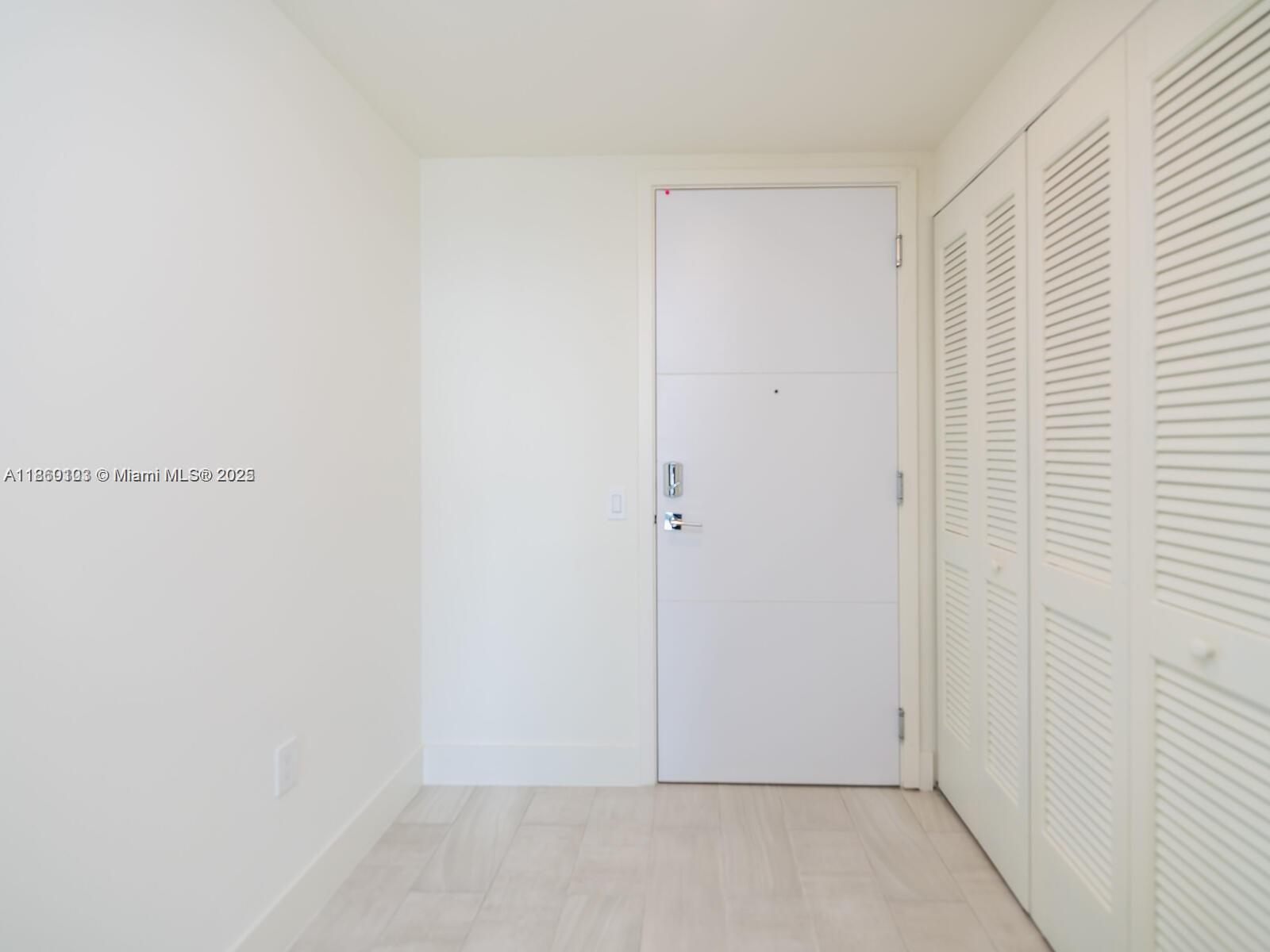 A white door and louvered closet doors are set against white walls and light flooring — 2000 Metropica Way # 2509, Sunrise FL 33323, SUNRISE, FL