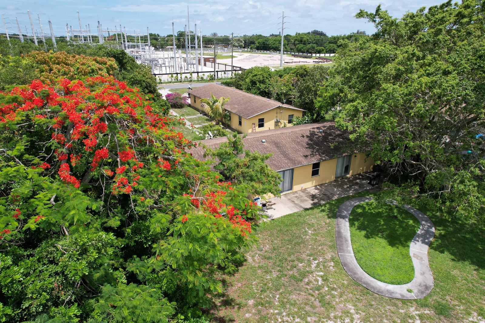 An aerial view shows two yellow single-story houses with brown roofs near a power substation — 4537 Coconut Road, Lake Worth FL 33461, LAKE WORTH, FL