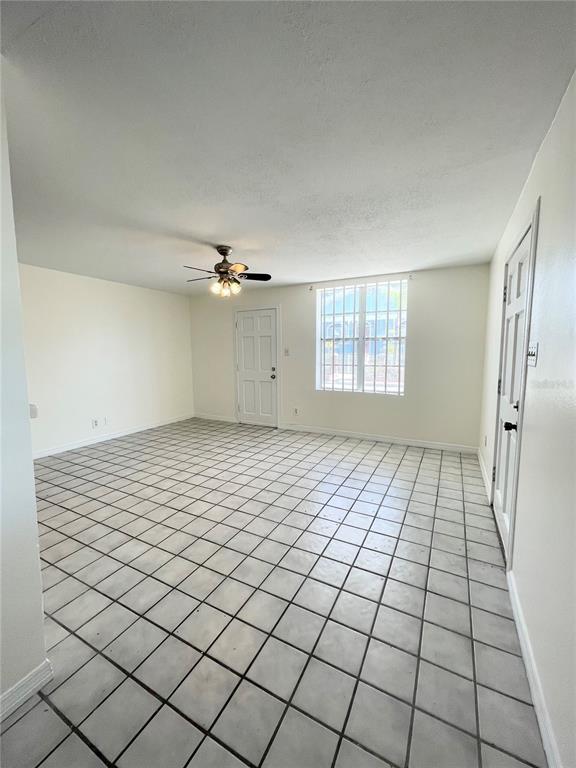A room with white walls, a ceiling fan, and light-colored square floor tiles — 2916 NORTH 16TH STREET UNIT 1, TAMPA, FL