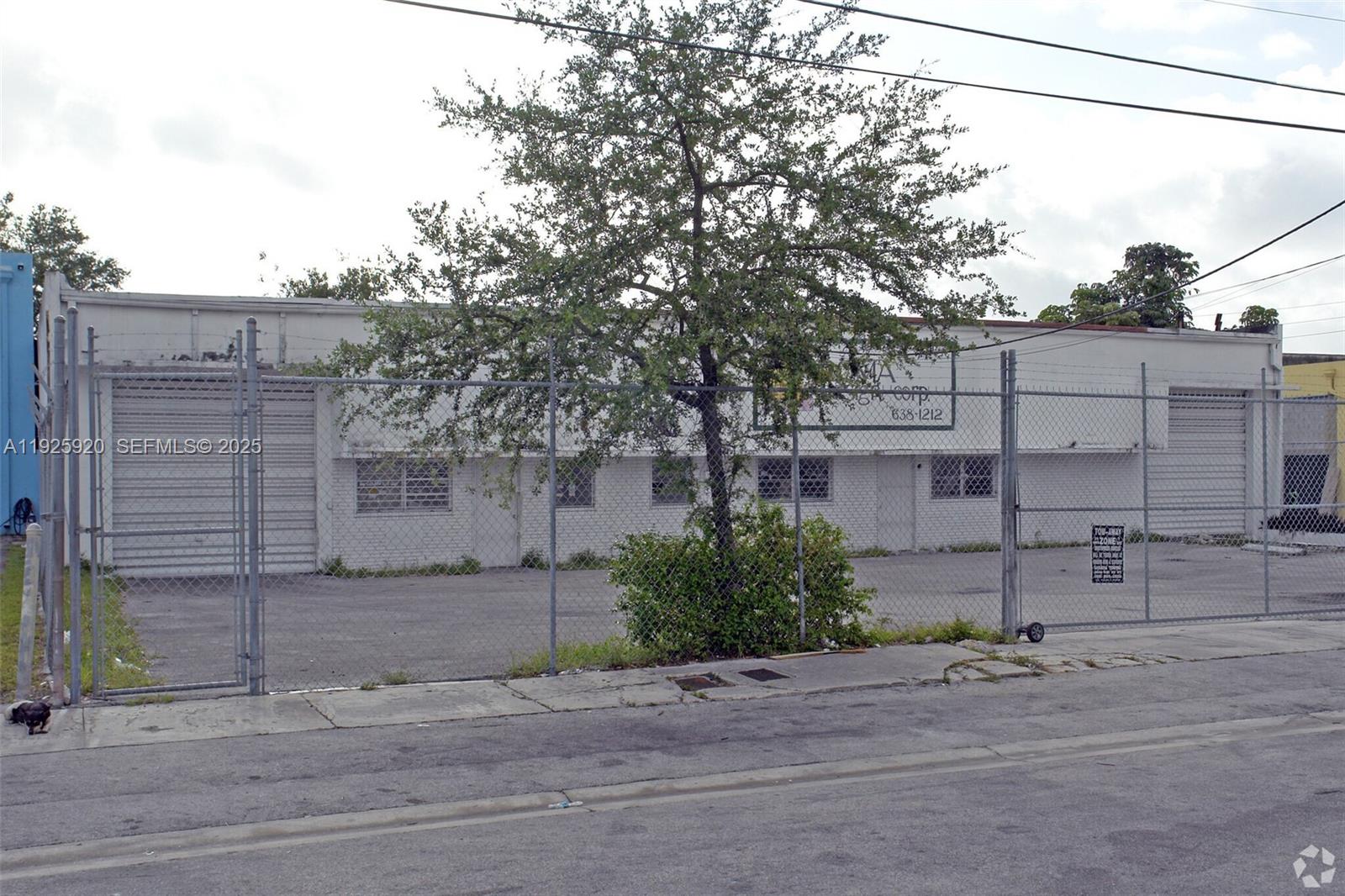 A single-story commercial building with a fenced parking lot and a large tree in front — 2175 NW 26th Ave, Miami FL 33142, MIAMI, FL