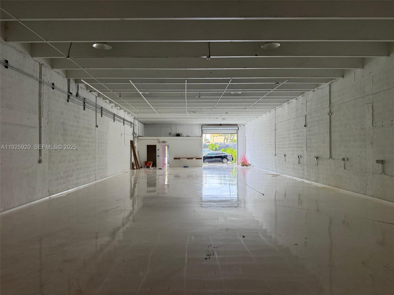 An empty industrial warehouse space features white painted block walls and a polished concrete floor — 2175 NW 26th Ave, Miami FL 33142, MIAMI, FL