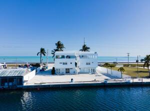 An aerial view of a white multi-story building situated along a waterfront canal — 74560 Overseas Highway, Islamorada FL 33036, ISLAMORADA, FL