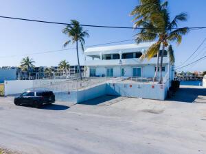 A light blue two-story building with palm trees and a parked car in the foreground — 74560 Overseas Highway, Islamorada FL 33036, ISLAMORADA, FL