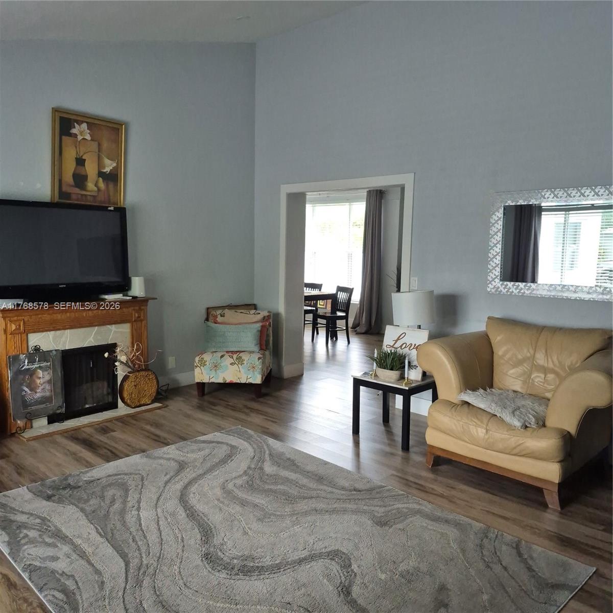 A living room features a fireplace, a patterned rug, and a tan leather armchair — 8320 NW 10 Ave, Miami FL 33150, MIAMI, FL