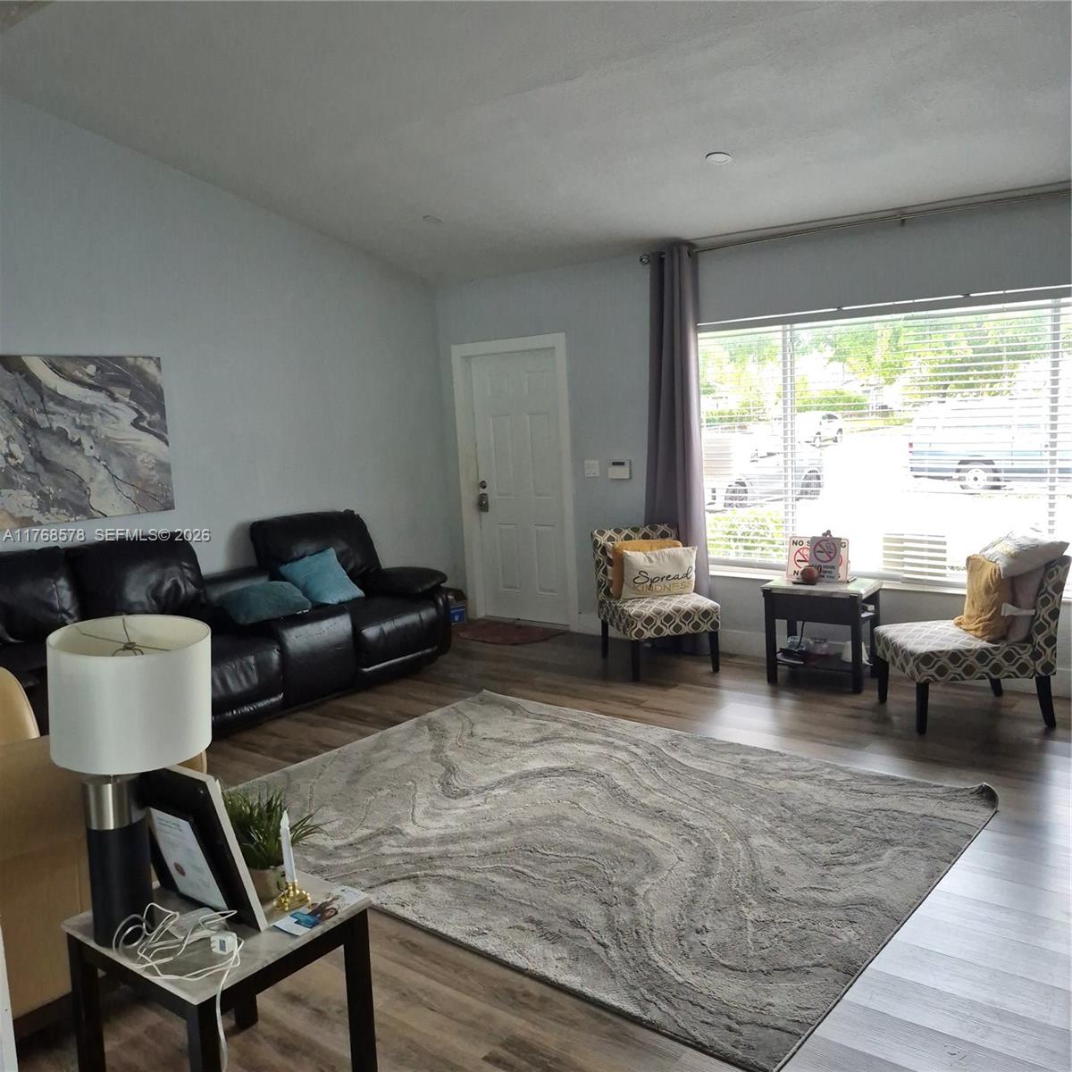 A living room features a black leather sofa, patterned accent chairs, and a large area rug — 8320 NW 10 Ave, Miami FL 33150, MIAMI, FL