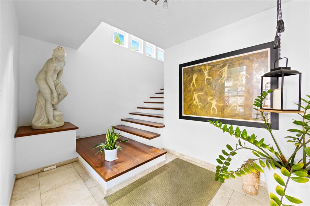 An entryway features a floating wooden staircase, a classical statue, and a large framed painting — 424 DEL VALLE ST MONTEFLORES DEV, SAN JUAN, PR