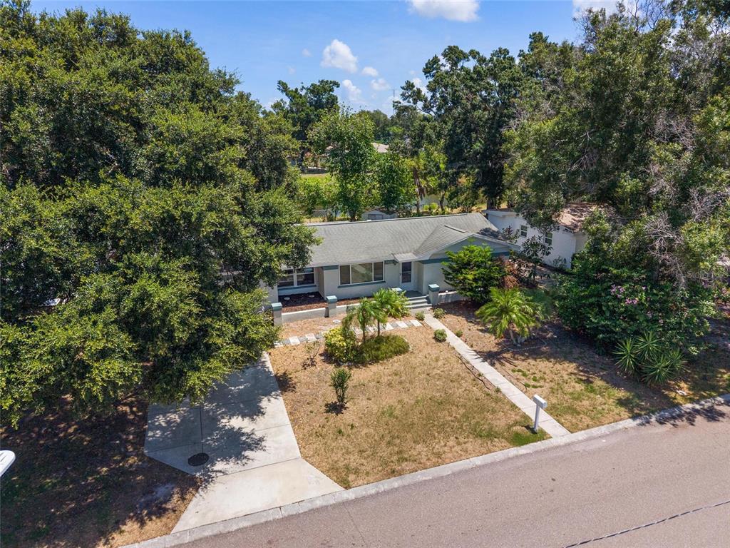 An aerial view of a single-story house with a driveway and mature trees — 1428 PINEBROOK DRIVE, CLEARWATER, FL