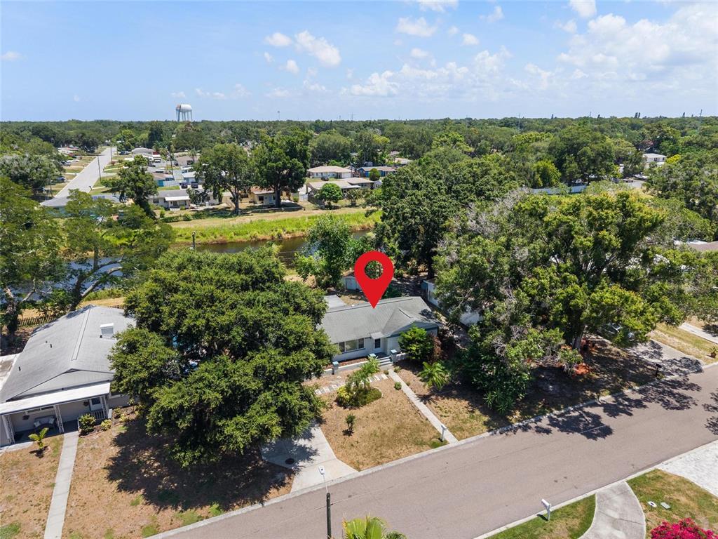 An aerial view shows a single-story house with a red location pin on its roof — 1428 PINEBROOK DRIVE, CLEARWATER, FL