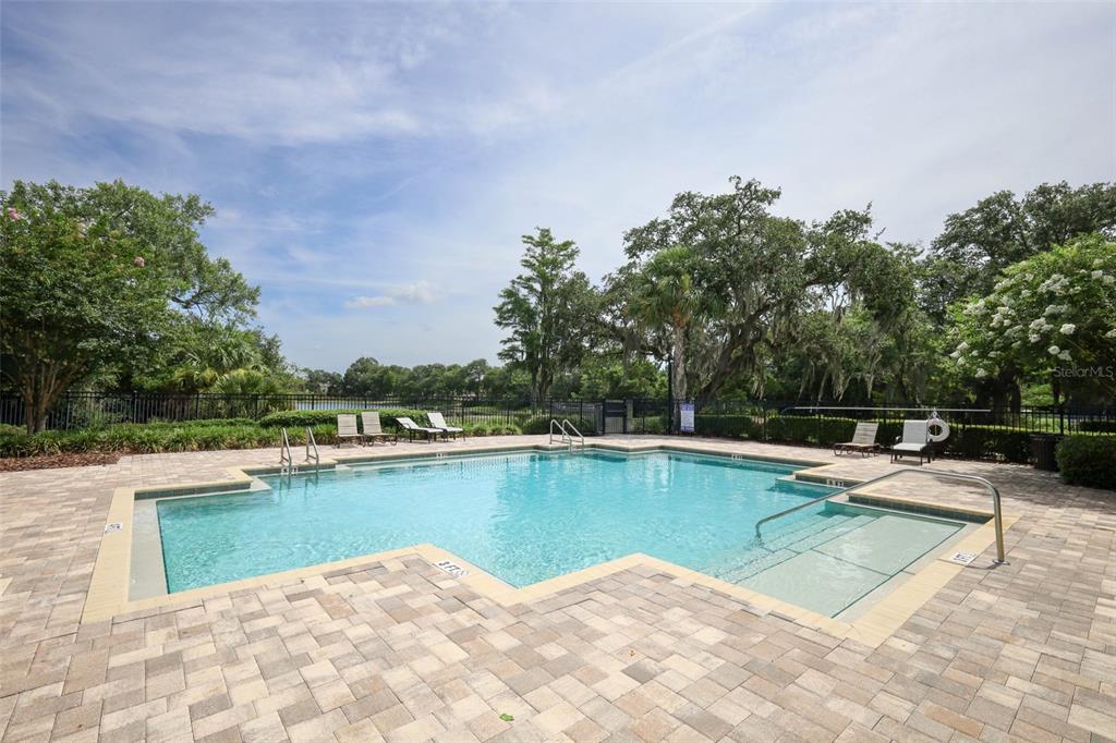 A kitchen with dark wood cabinets, granite countertops, stainless steel appliances, and a central island — 3802 BISHOP LANDING WAY, ORLANDO, FL