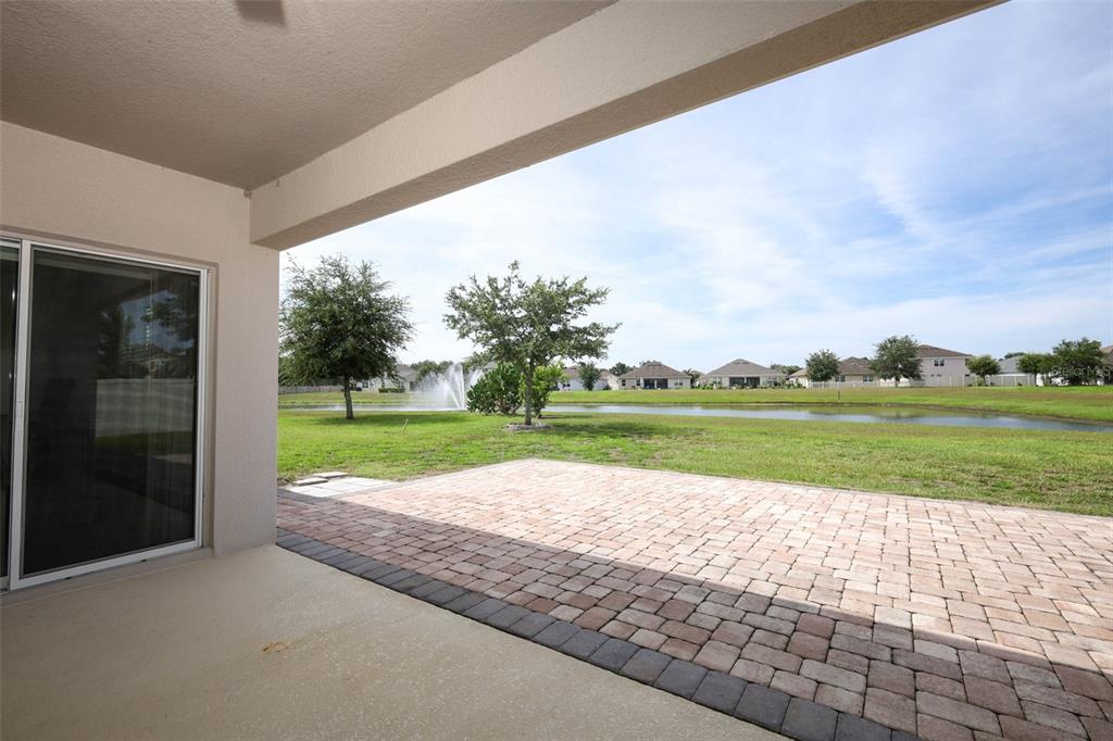 A kitchen features dark wood cabinets, granite countertops, a center island, and tile flooring — 3802 BISHOP LANDING WAY, ORLANDO, FL