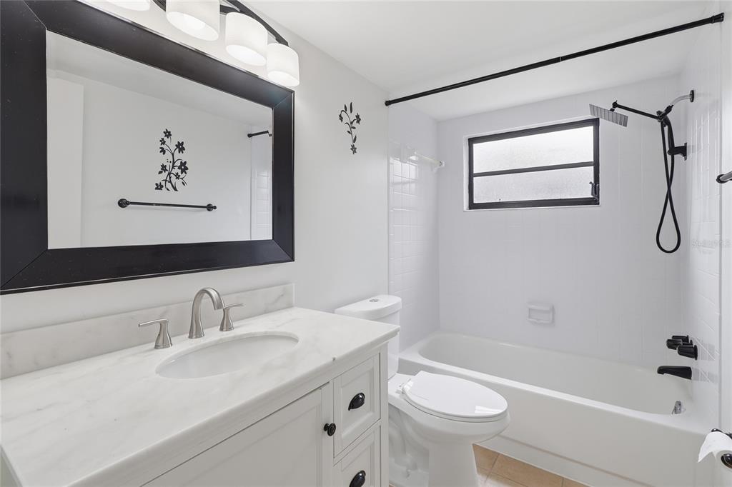 A bathroom features a white vanity with a marble countertop, a toilet, and a bathtub — 804 CENTERWOOD COURT, BRANDON, FL