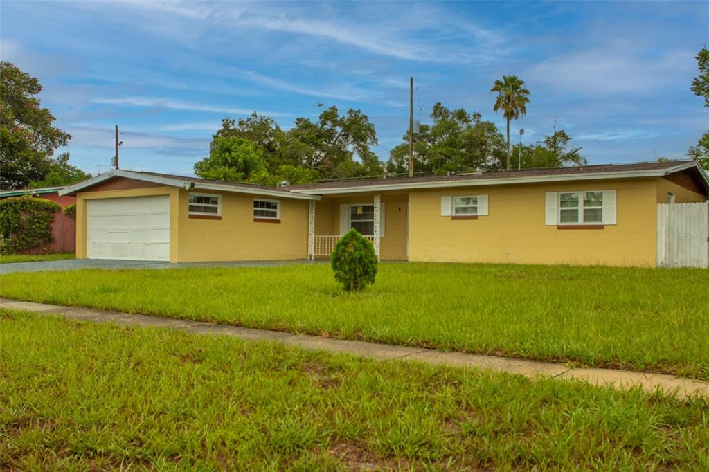 A single-story yellow house with a two-car garage and a front lawn — 4835 KATHY JO TERRACE, ORLANDO, FL