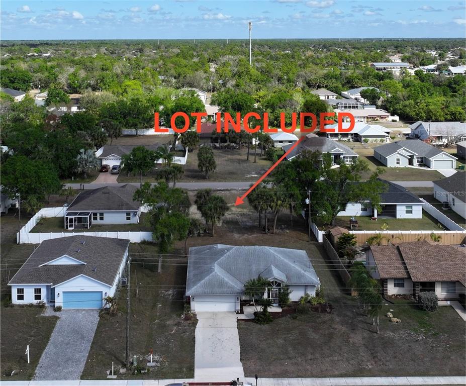 An aerial view shows a residential house with an adjacent vacant lot behind it — 22450 PEACHLAND BOULEVARD, PORT CHARLOTTE, FL