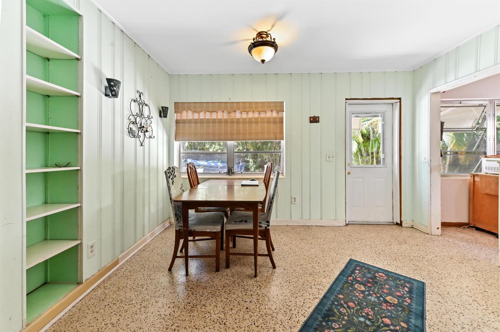 A dining area features light green paneled walls, a wooden table, and terrazzo flooring — 411 N Lakeside Drive, FL 33460, FL