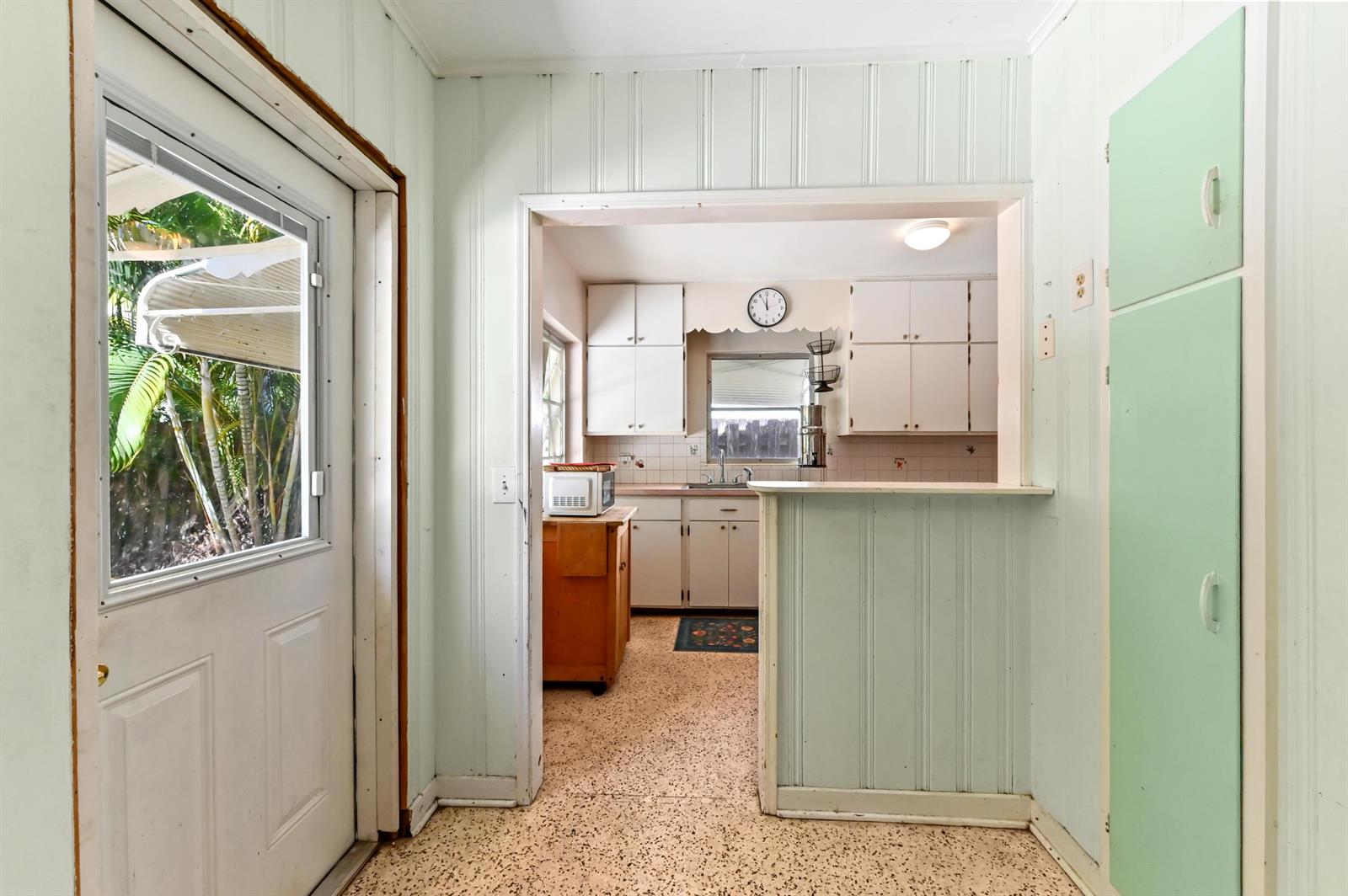 A view from a doorway looking into a kitchen with light green paneling and cabinets — 411 N Lakeside Drive, FL 33460, FL