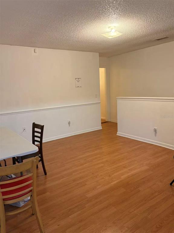 A dining area features wood-look laminate flooring, white walls with chair rail molding, and chairs — 1160 WOODMAN WAY, ORLANDO, FL