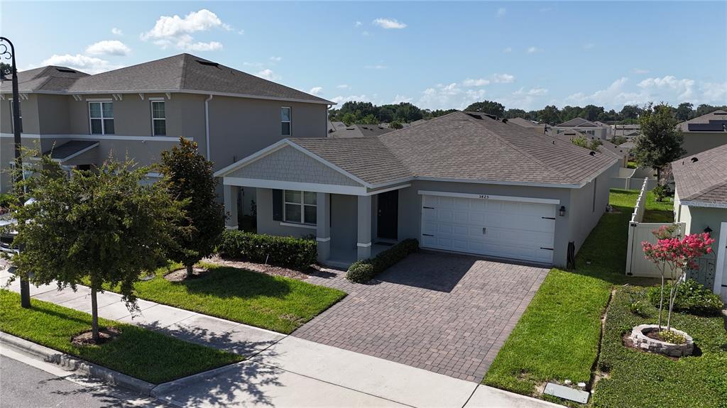 A single-story house with a brick driveway, white garage door, and a covered front porch — 5425 PALOMINO PL, APOPKA, FL