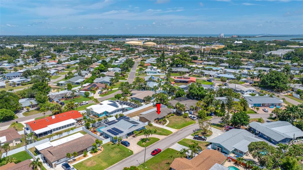An aerial view shows a residential neighborhood with a red arrow pointing to a house — 5056 42ND STREET S, ST PETERSBURG, FL