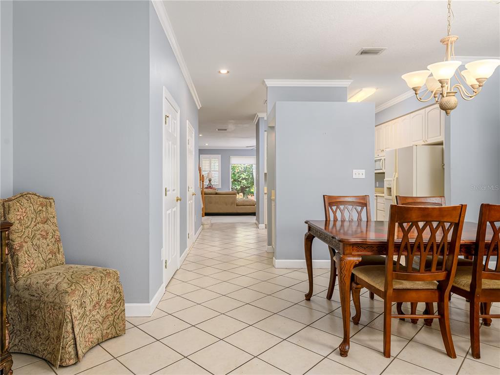 A dining area with a wooden table and chairs sits beside a tiled hallway — 204 S LINCOLN AVENUE, TAMPA, FL