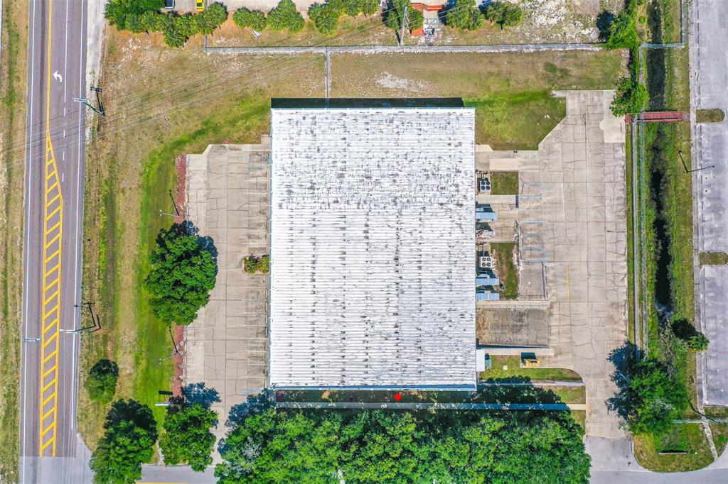 An aerial view shows a rectangular industrial building with a flat roof and paved parking lots — 295 BARNES BOULEVARD, ROCKLEDGE, FL