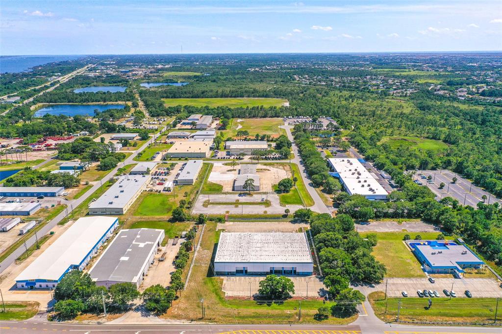 An aerial view shows several industrial warehouse buildings surrounded by parking lots and green space — 295 BARNES BOULEVARD, ROCKLEDGE, FL
