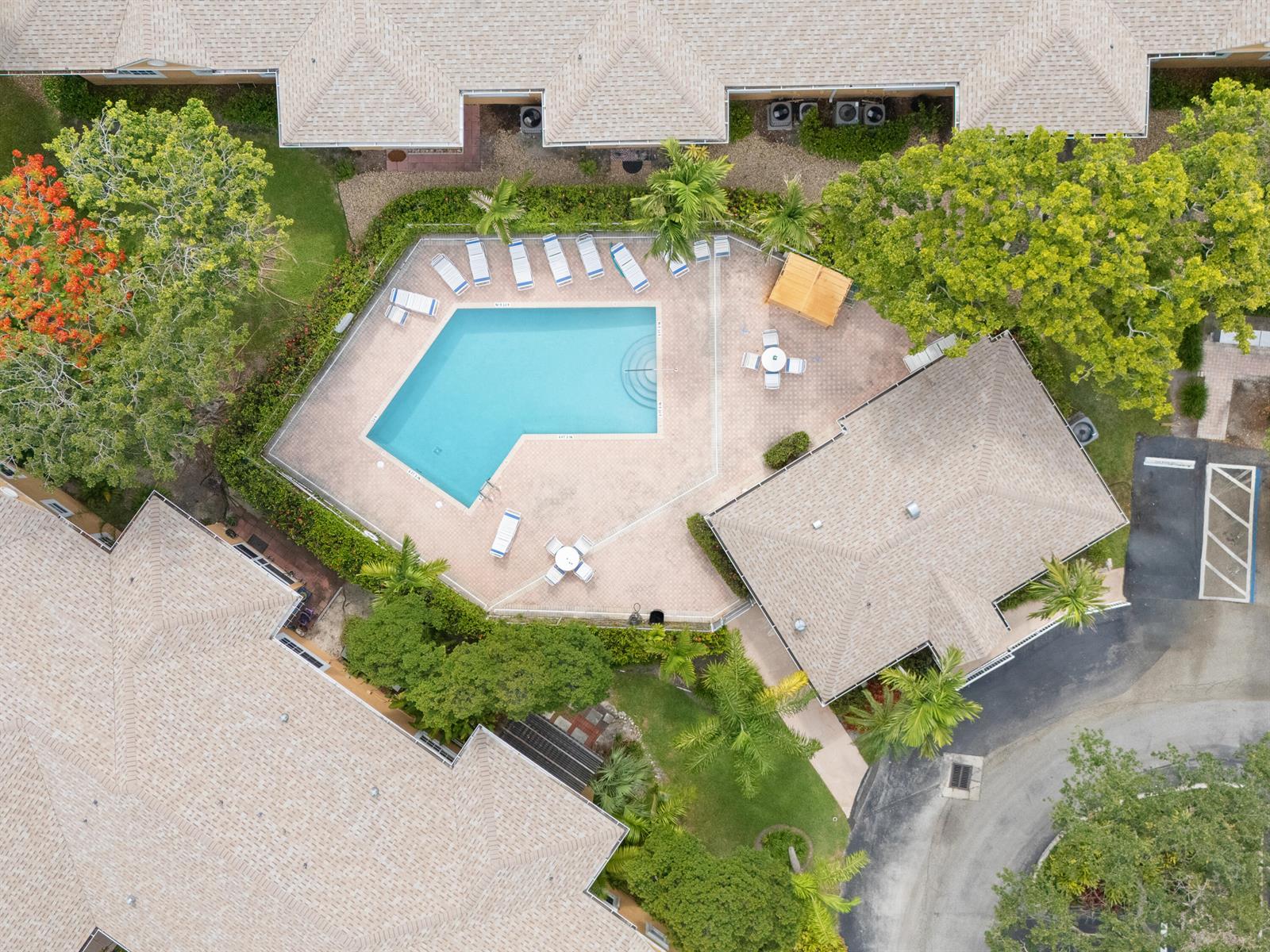 An aerial view shows a swimming pool with lounge chairs and a patio area — 811 SE 4th Avenue # C103, Dania Beach FL 33004, DANIA BEACH, FL
