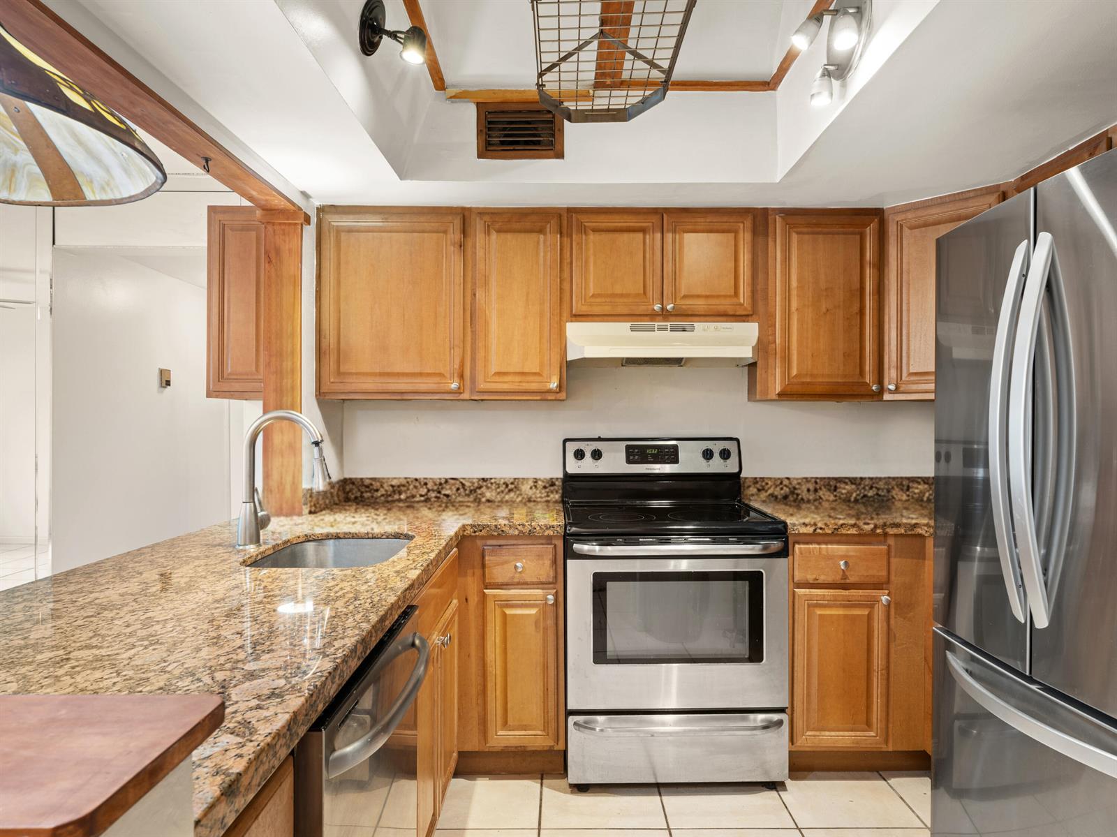 A kitchen features wood cabinets, granite countertops, stainless steel appliances, and a recessed ceiling — 811 SE 4th Avenue # C103, Dania Beach FL 33004, DANIA BEACH, FL