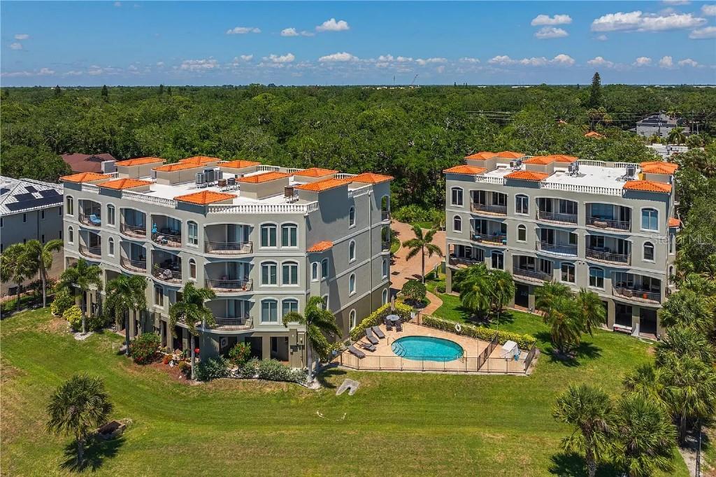 An aerial view of two multi-story apartment buildings with orange tile roofs and a pool — 1714 PARK STREET N, ST PETERSBURG, FL