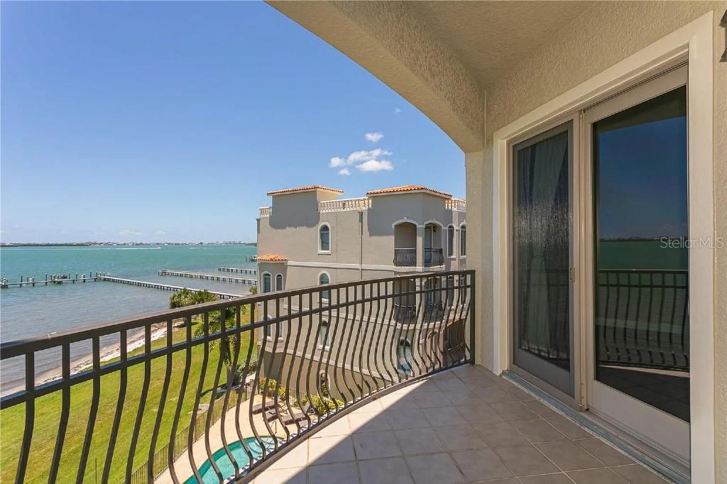 A balcony with a metal railing overlooks a bay, a pier, and a neighboring building — 1714 PARK STREET N, ST PETERSBURG, FL